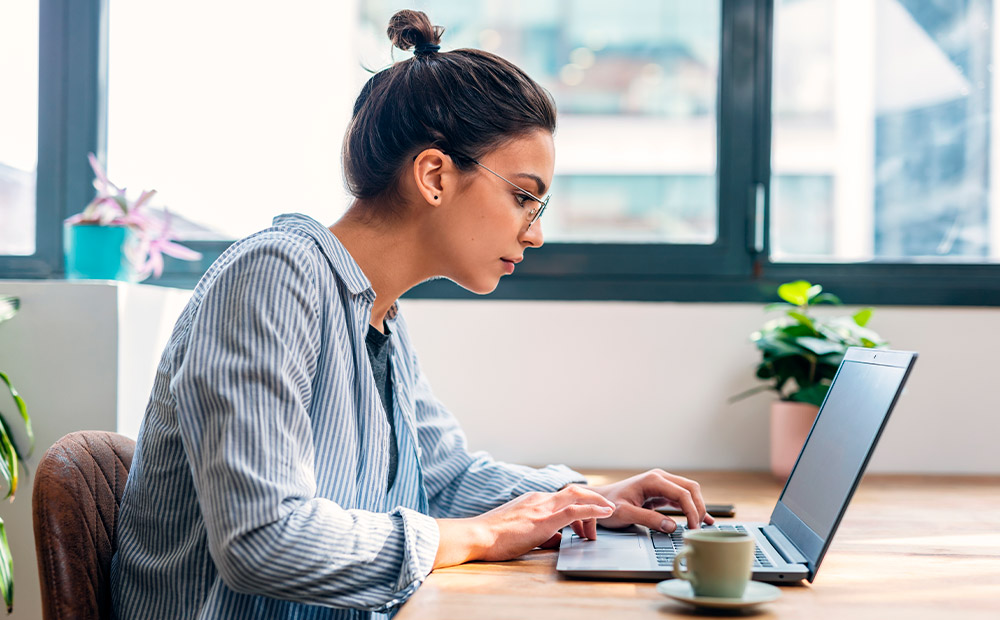 Perfil joven empresaria trabajando portátil oficina