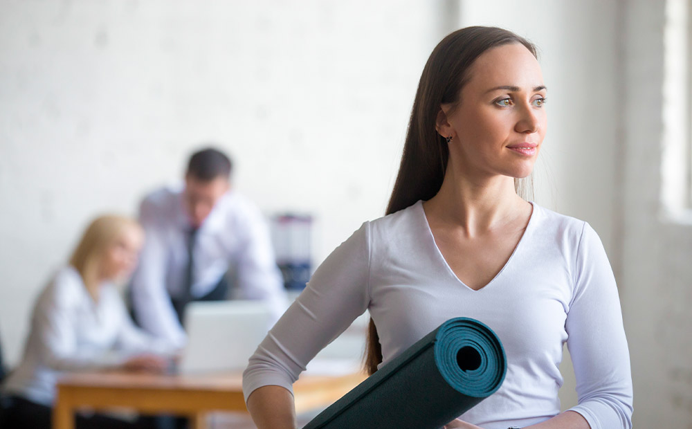 Empleada sosteniendo esterilla yoga empresa