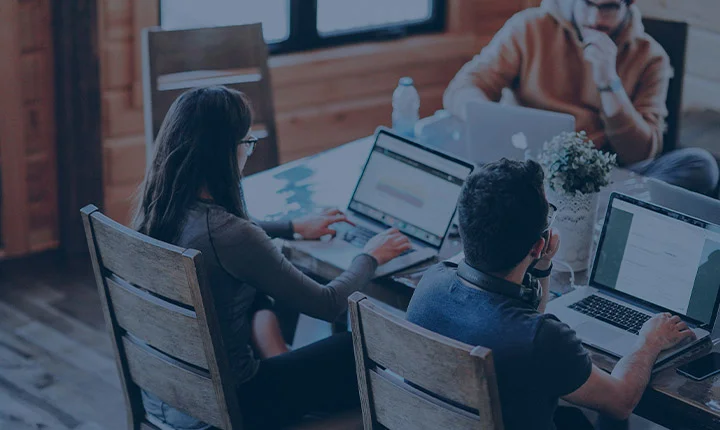 personas sentadas en mesa con portatil