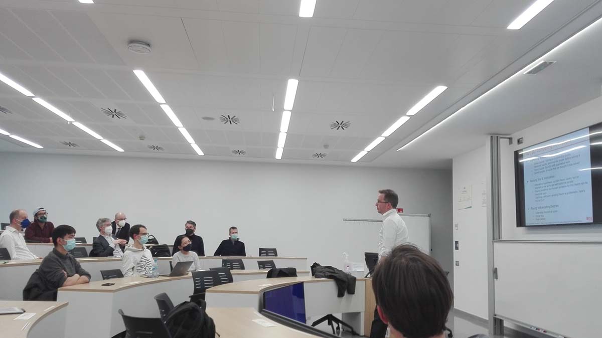 Personas en un aula escuchando a un profesor