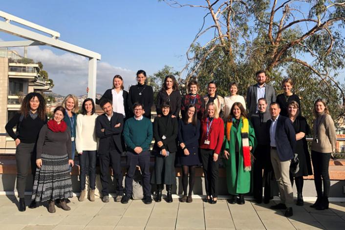 Gran grupo de personas posando juntas de pie en el exterior