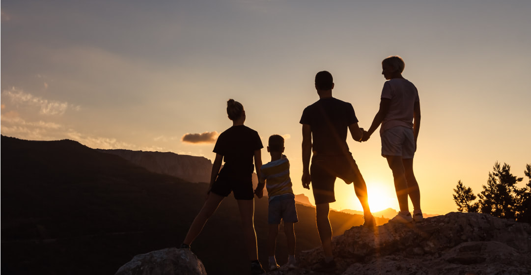 Familia en la cima de una montaña, a contraluz