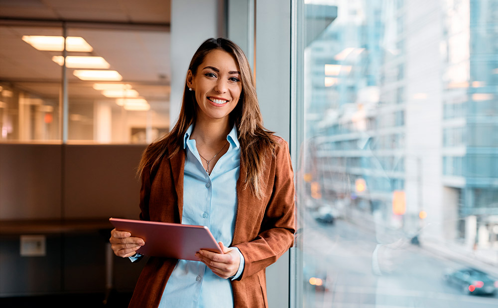 Mujer emprendedora sonriendo sosteniendo tableta empresa