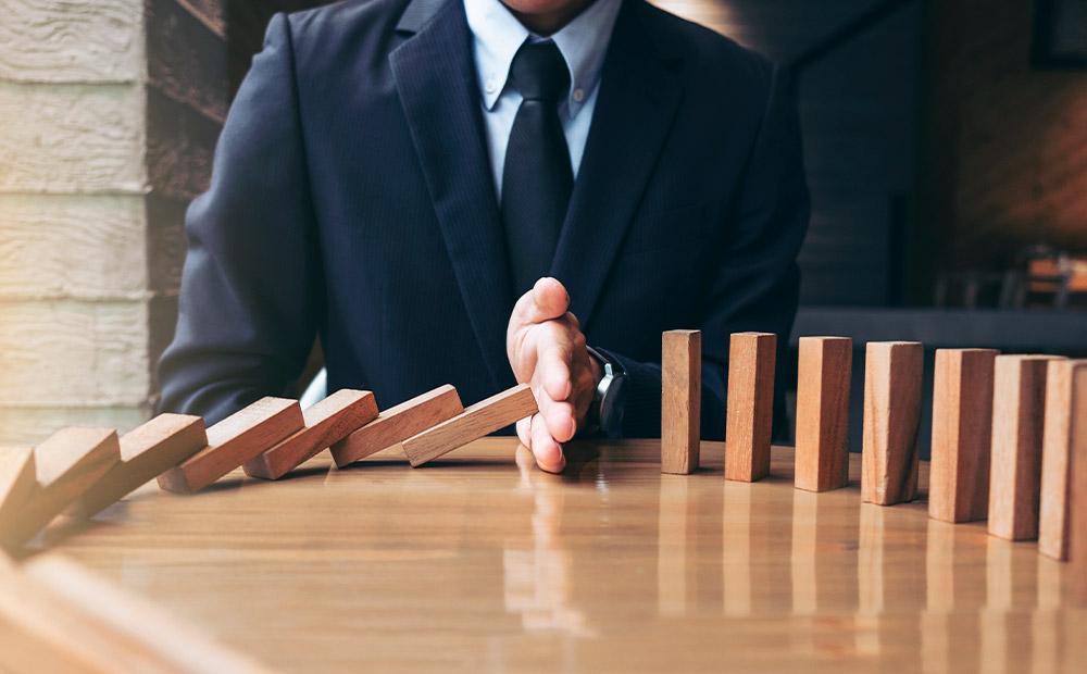 Persona negocios parando mano caída dominó madera