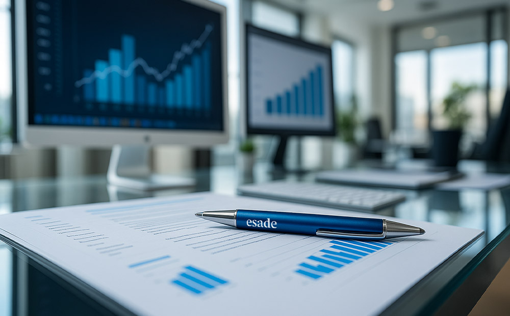 Una oficina moderna con dos monitores que exhiben gráficos de barras y líneas ascendentes, junto a un documento impreso con datos similares y un bolígrafo con la marca Esade en primer plano. Esta escena representa el análisis y seguimiento del rendimiento empresarial, elementos fundamentales en la formulación de una estrategia corporativa sólida.