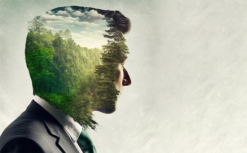 En la imagen se aprecia la silueta de una persona de perfil, en cuyo interior se superpone un frondoso paisaje natural lleno de árboles verdes y un cielo luminoso, creando un efecto visual que fusiona mente y naturaleza.